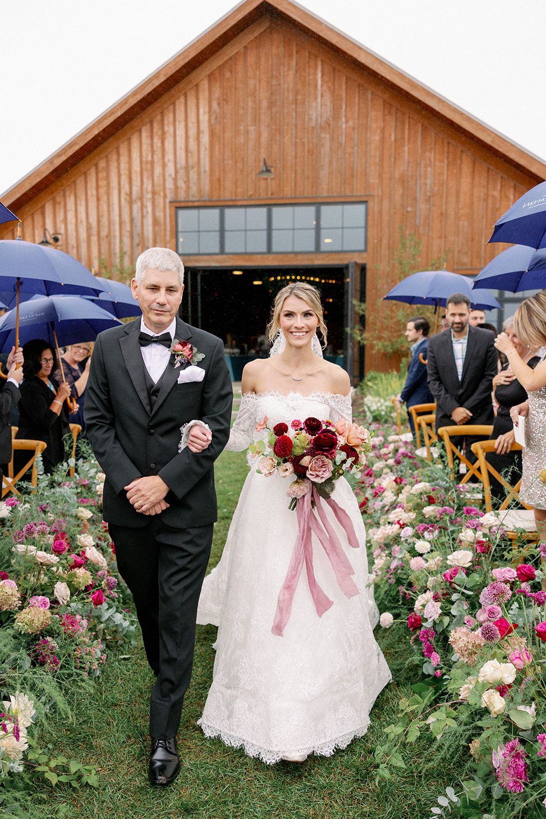 bride with her father walking down the aisle at lake house wedding 