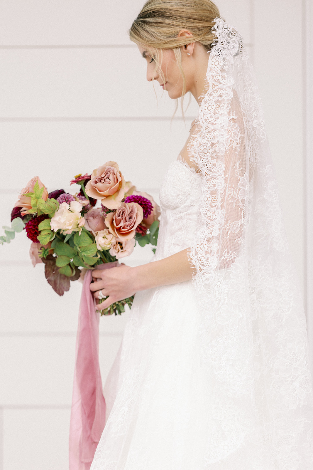 bride looking down at her beautiful flower bouquet 