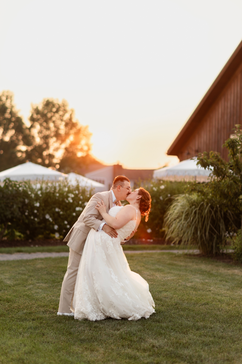 Groom dips bride for portrait during their wedding ceremony.