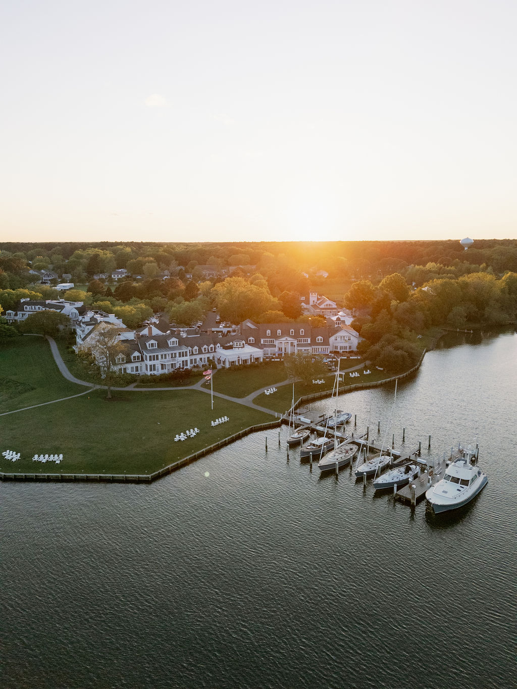 Aerial view of Inn at PerryCabin wedding venue at sunrise, with the sun coming up above the horizon.
