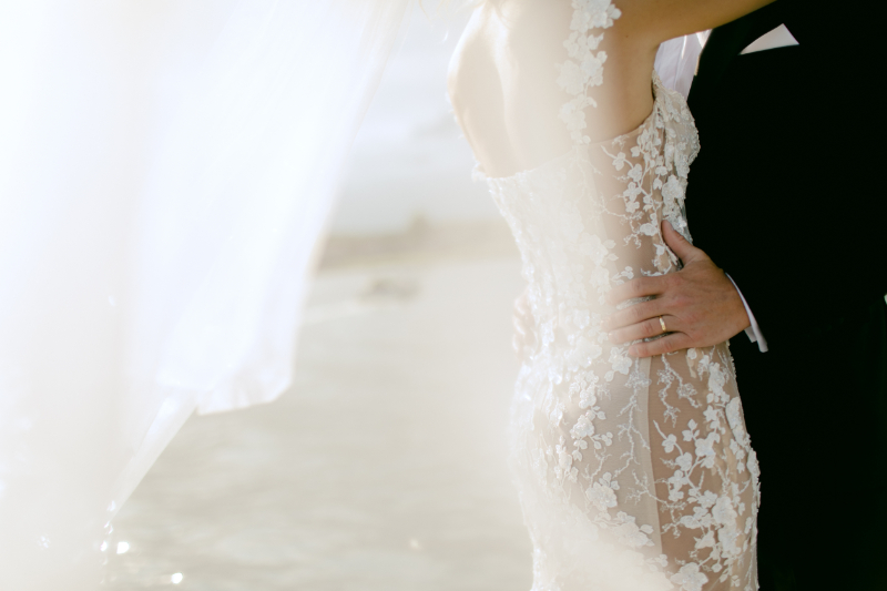 Closeup of bride lace dress at lake house wedding 