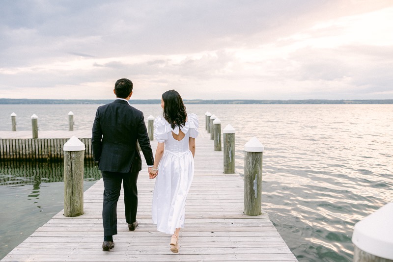 bride and groom walk on the dock