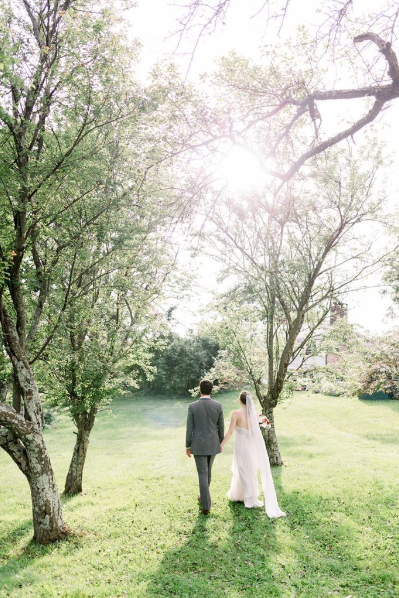 Bride and groom walking hand in hand at Glynwood. 