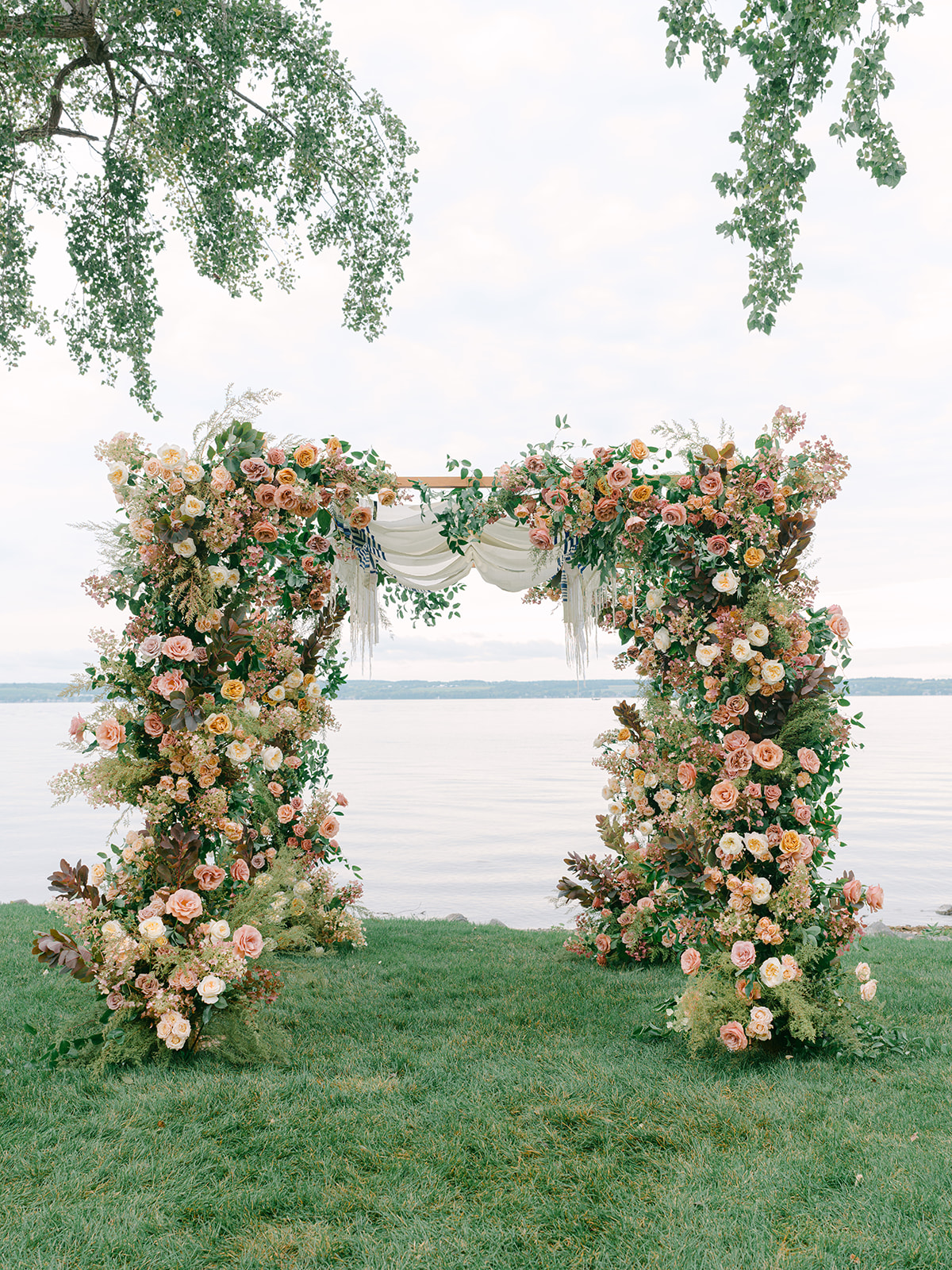 View of floral arch with fall wedding design and lake at Inns of Aurora.