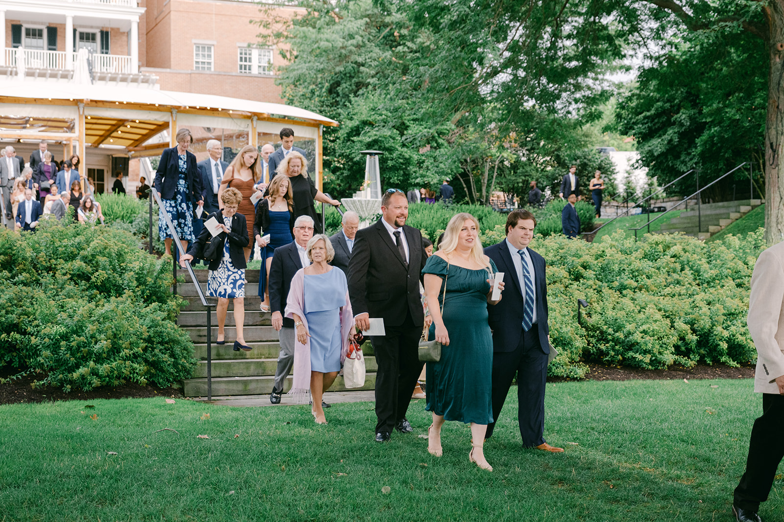 Wedding guests walk to their seats during ceremony at Inns of Aurora.
