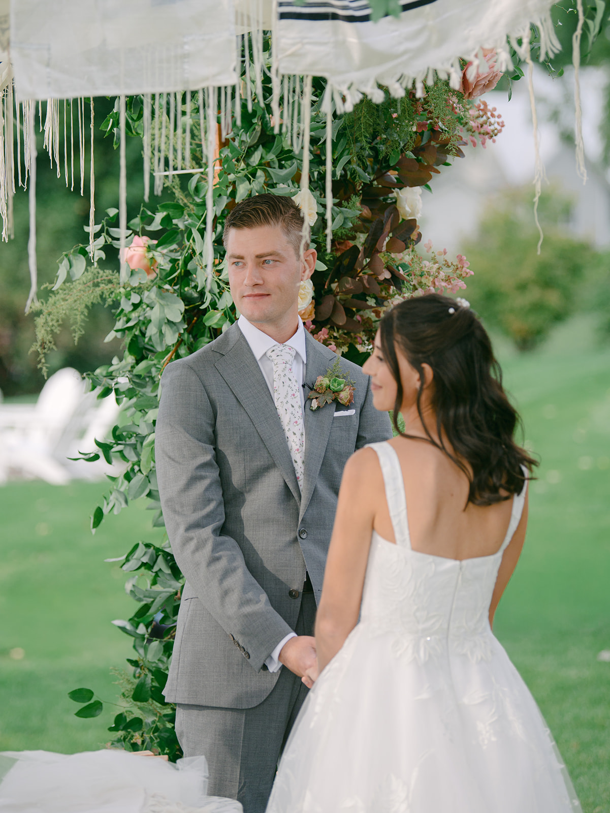 Bride and groom stand together holding hands during wedding ceremony at Inns of Aurora.