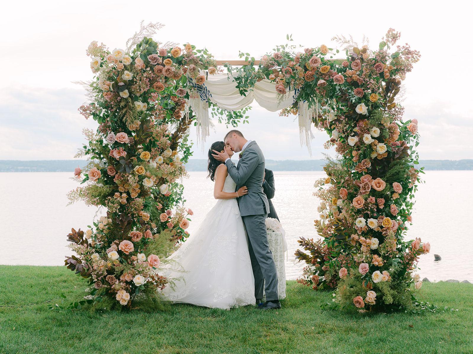 Bride and groom kiss at the alter during wedding ceremony at Inns of Aurora.