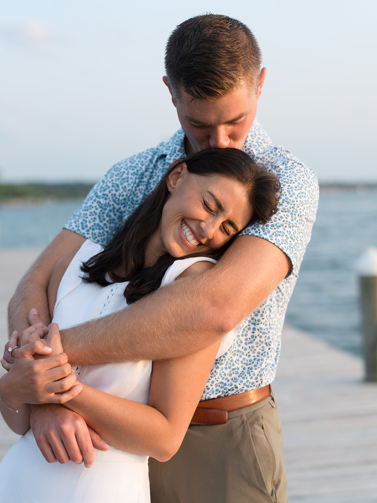 Couple embrace on the dock of Inns of Aurora before their welcome party.