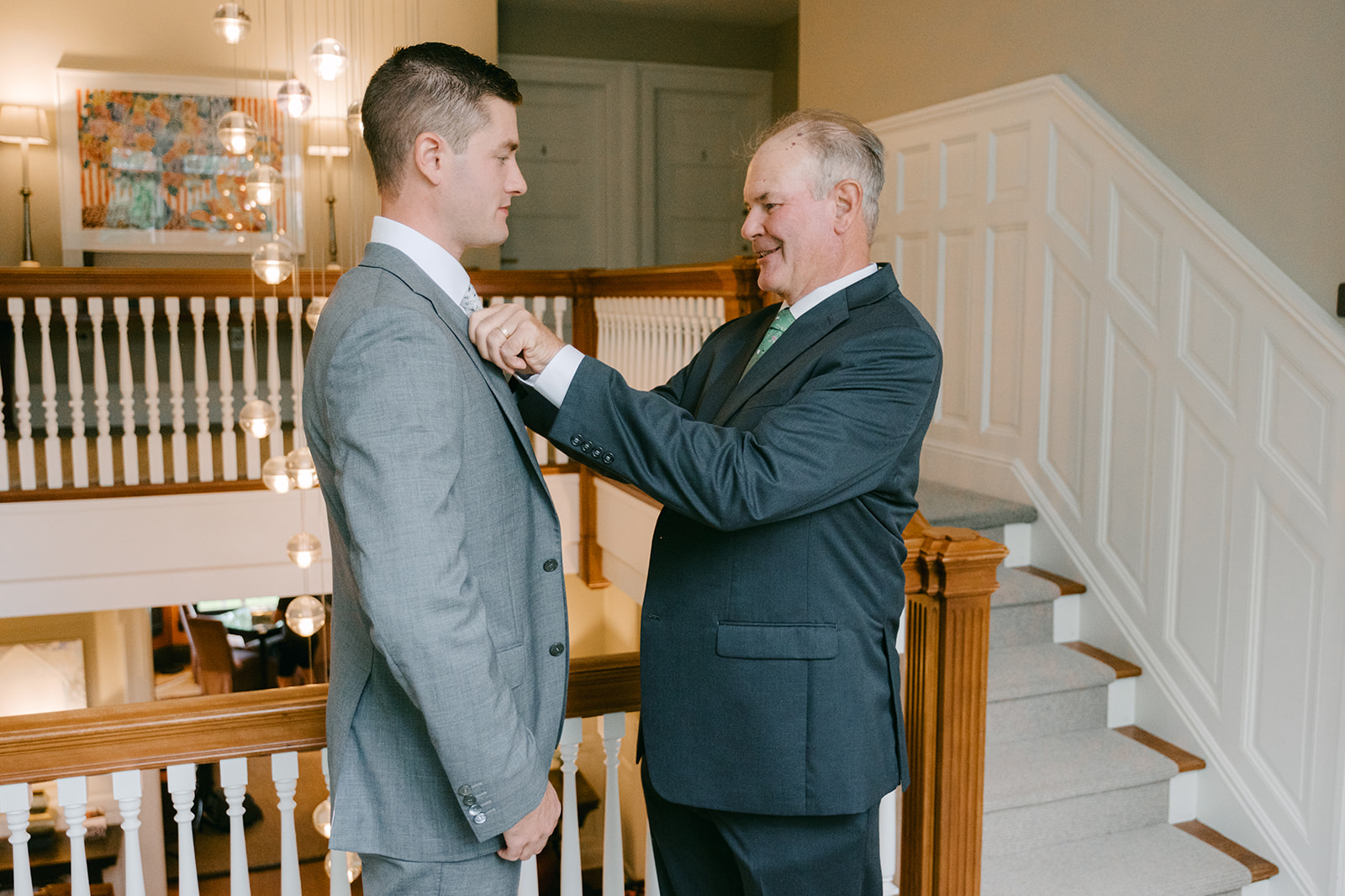 Father adjusts his son's tie as he gets ready for his wedding day.