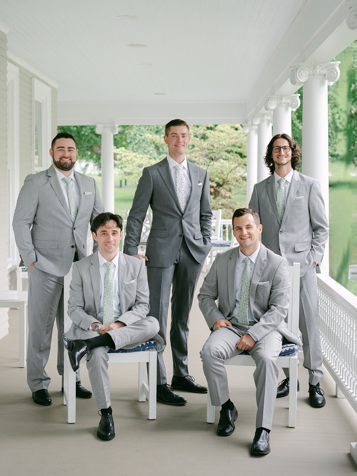 Groomsmen pose on porch of Inns of Aurora before wedding day begins.