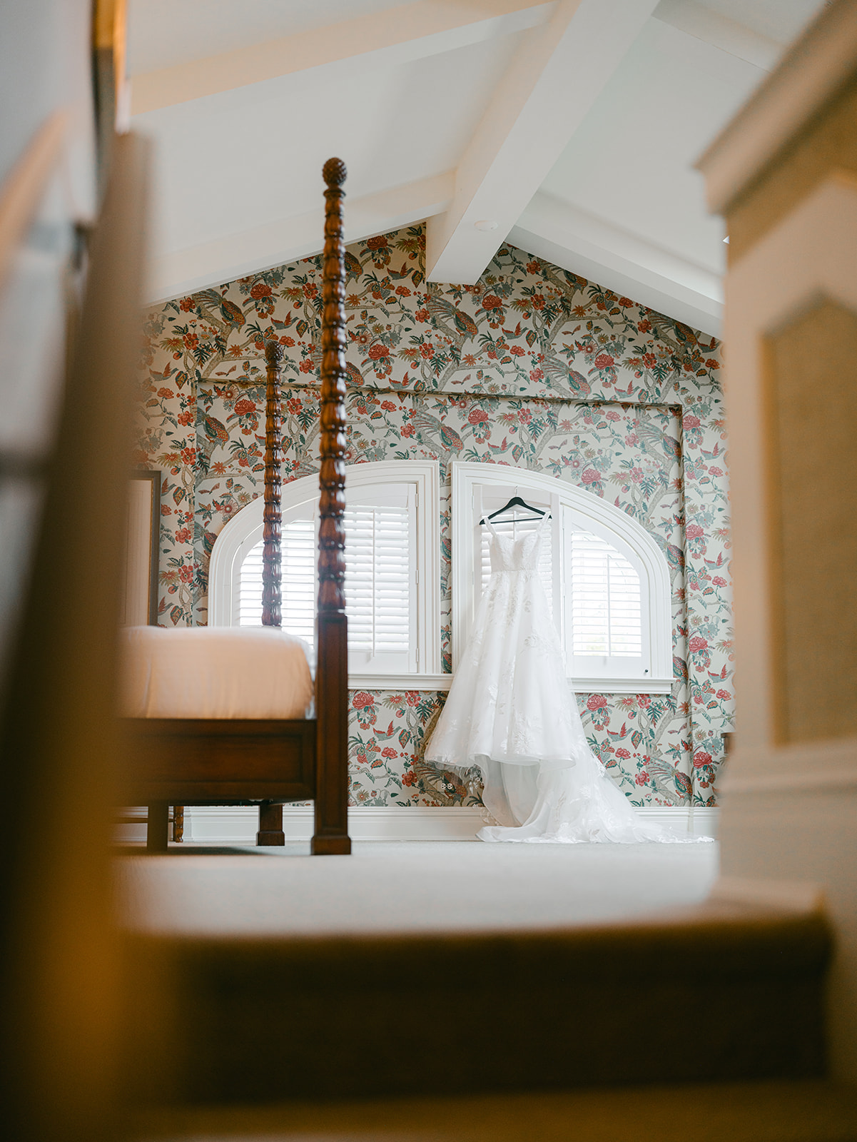 Bride's dress hangs in front of window in bridal suite at Inns of Aurora.