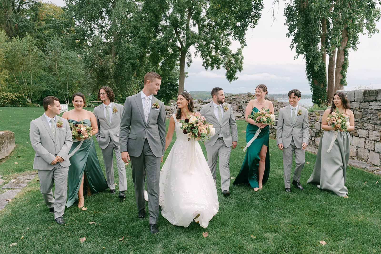 Bride and groom walk hand in hand as they take group photos with their wedding party at Inns of Aurora.