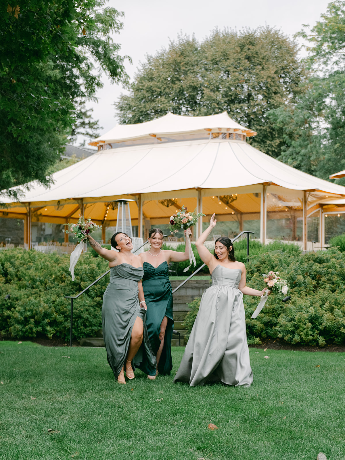 Bridesmaids get excited as they walk toward group portrait location at Inns of Aurora.