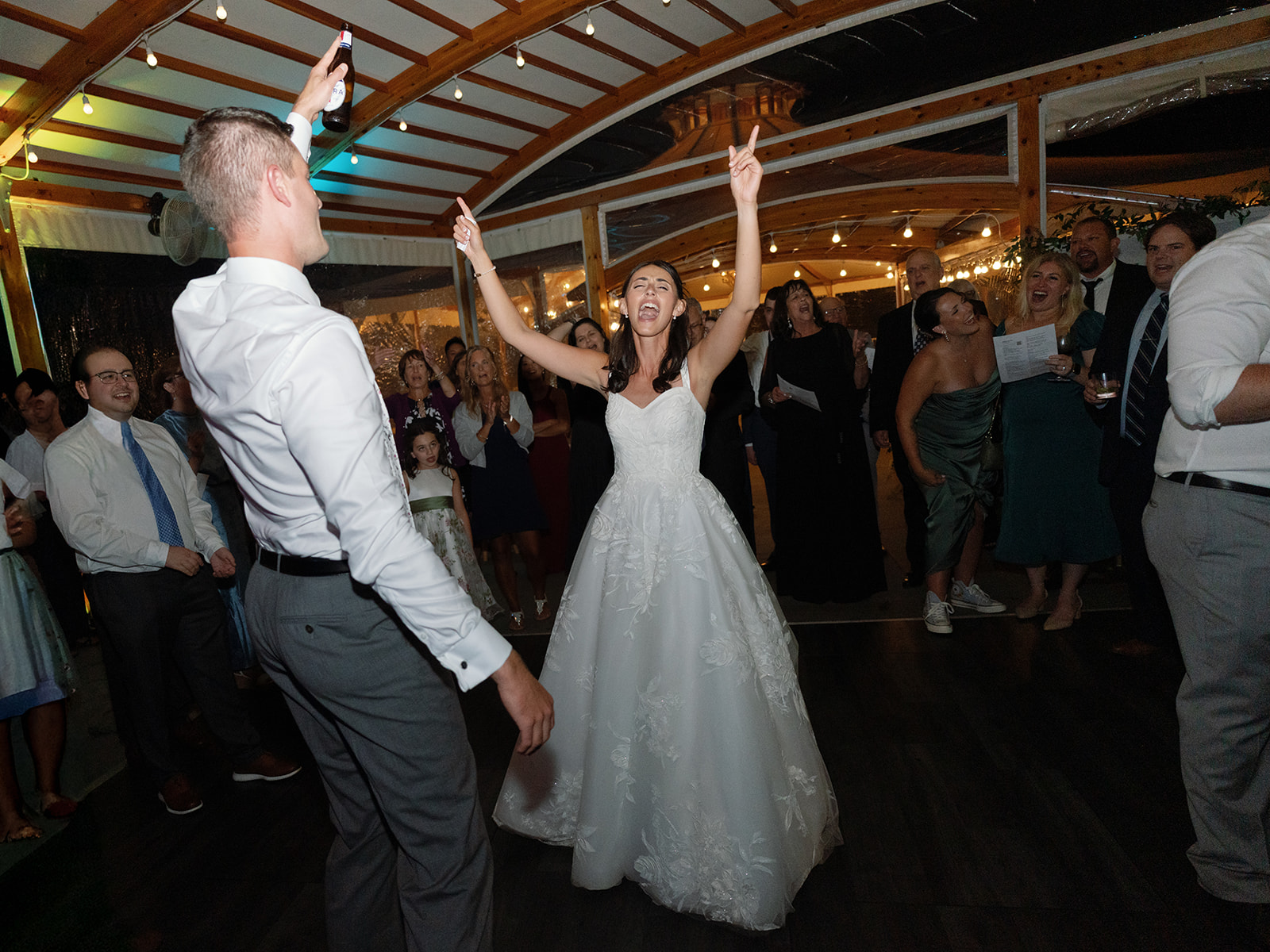 Bride and groom sing and dance together during wedding reception.