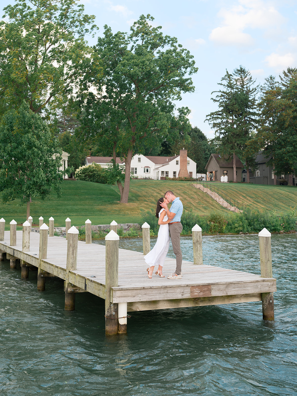 Couple embrace on the dock of Inns of Aurora during their welcome party.