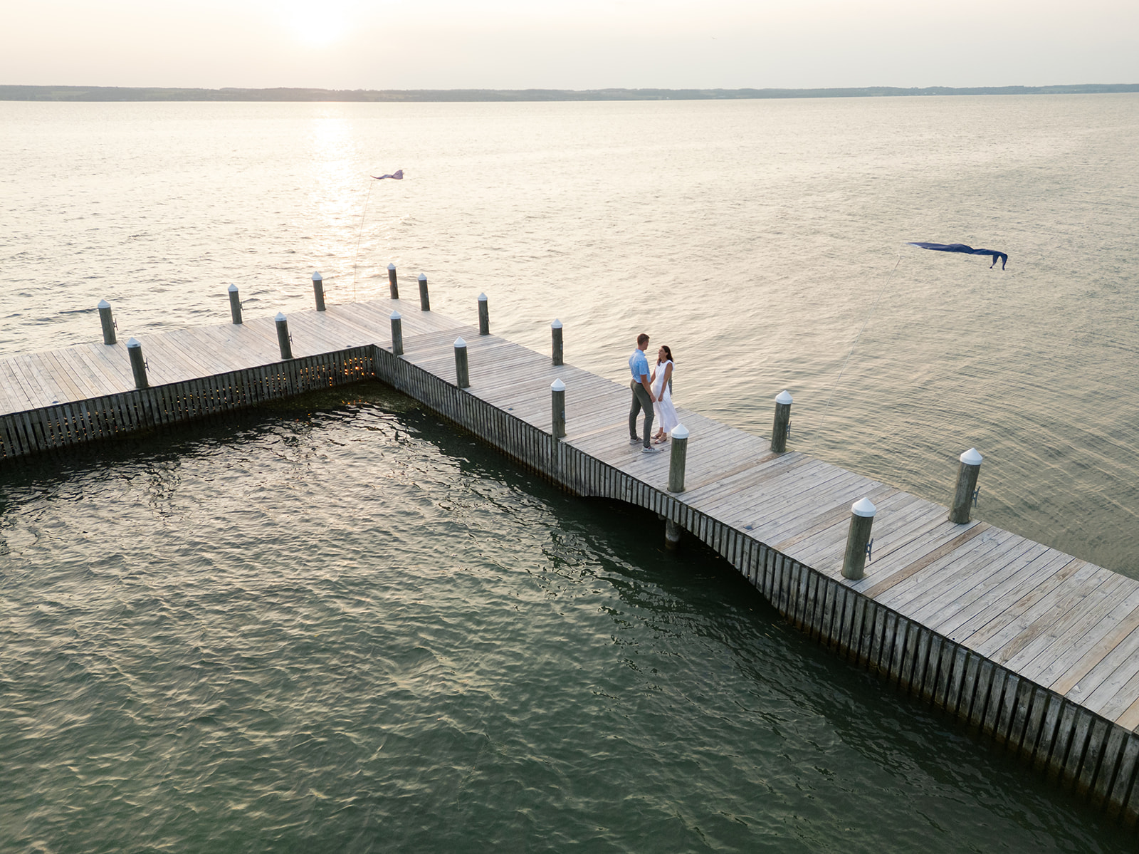 Couple embrace on the dock of Inns of Aurora before their welcome party.