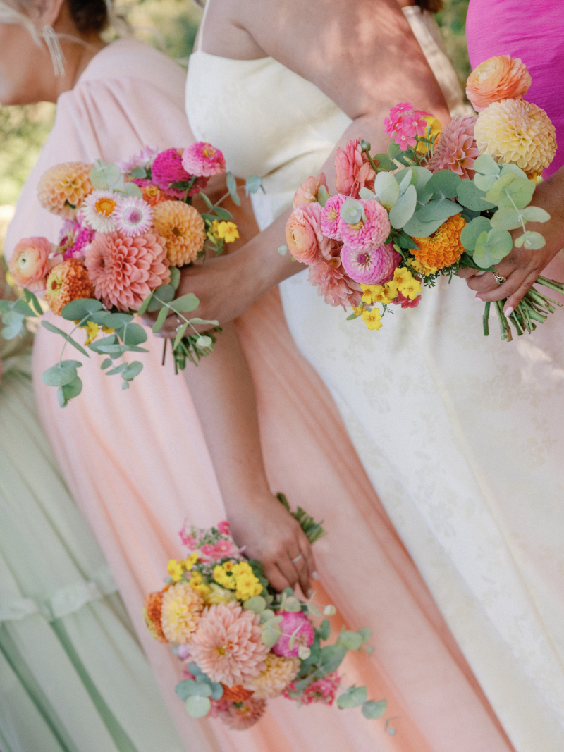 Close up of bridesmaid bouquets as they stand during ceremony.