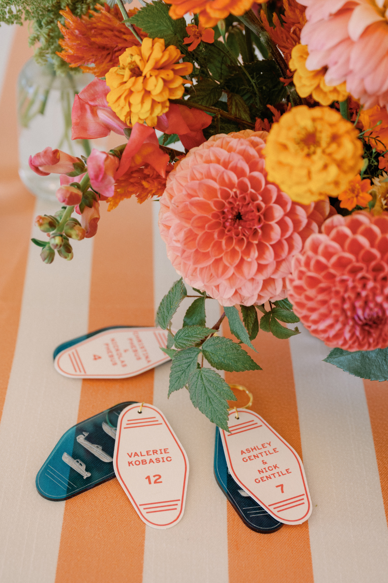 Custom boat key chain as escort card sitting underneath colorful florals.