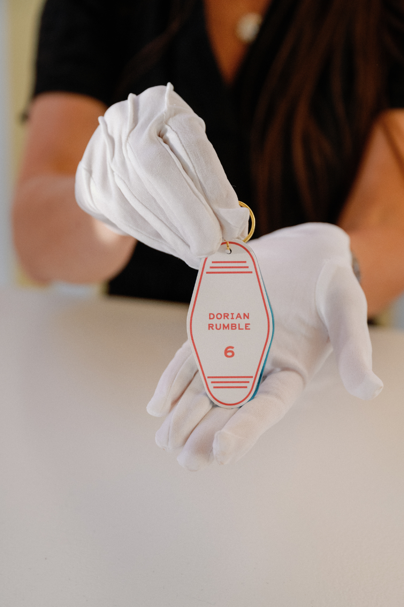 Venue staff presenting custom boat key escort card to guest.