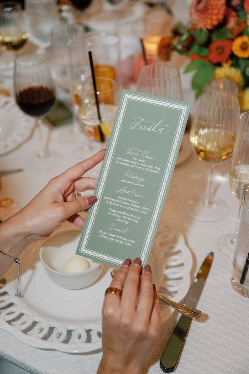 Guest holds up custom menu during wedding reception.