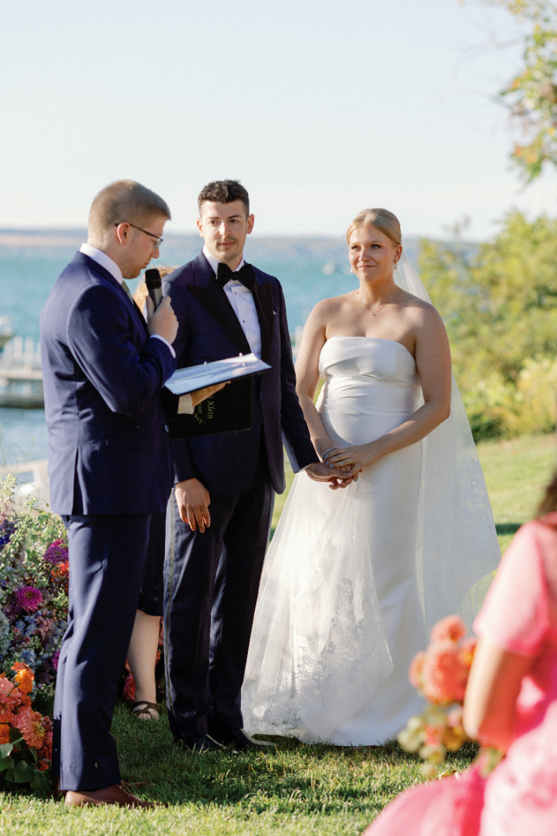Groomsman reads a poem during wedding ceremony as the bride and groom watch with joy.