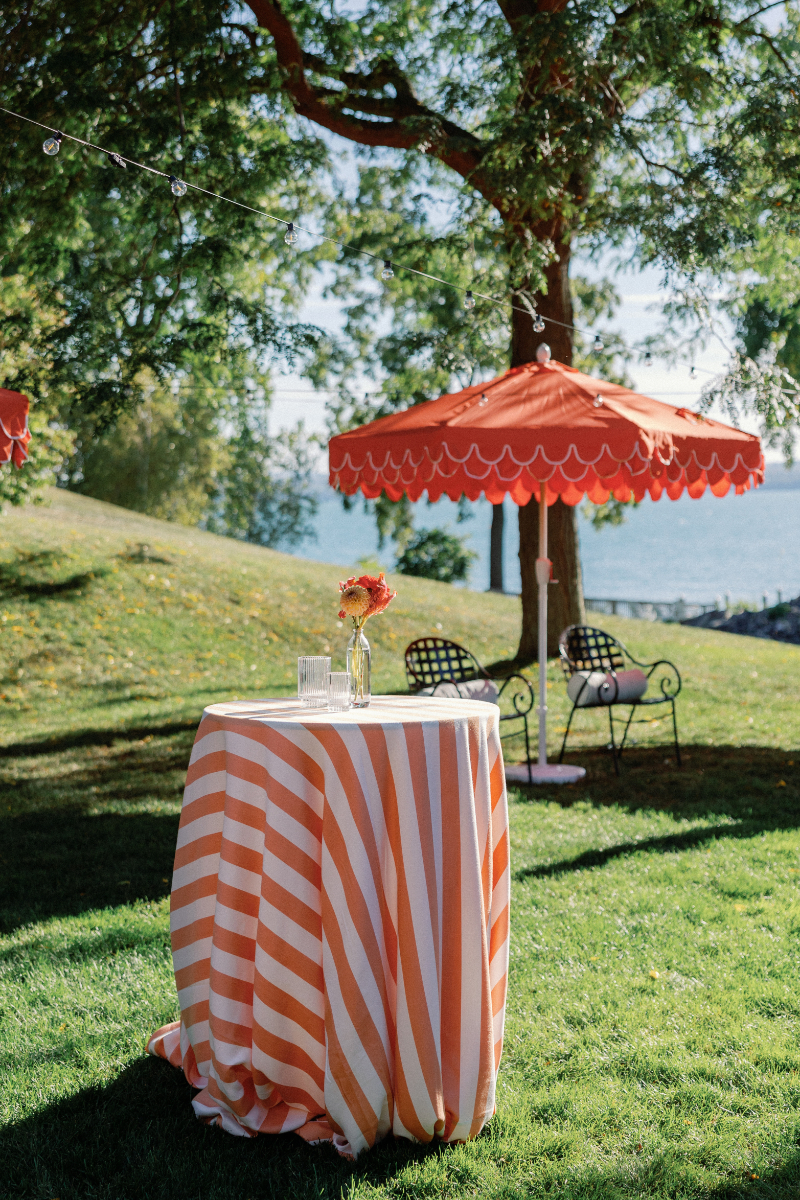 Cocktail tables on the lawn with striped linens.