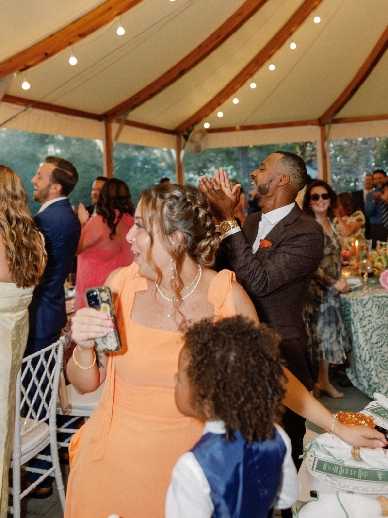 Guests stand and cheer as bride and groom make their grand entrance.