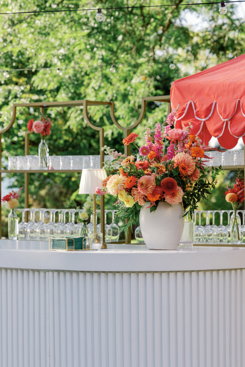 Bold, colorful floral arrangement for cocktail hour bar.