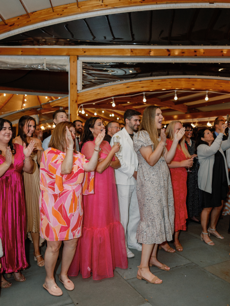 Guests stand and cheer as bride and groom make their grand entrance.
