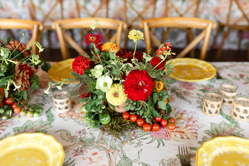 Heirloom tomato-inspired summer camp wedding welcome party floral arrangement.
