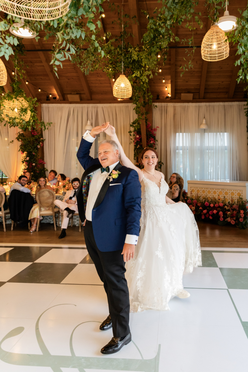 Bride shares dance with her father on custom monogrammed dance floor.