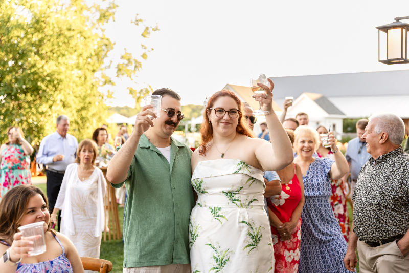Bride and groom raise their glasses during a toast at their wedding welcome part at the Lake House on Canandaigua.
