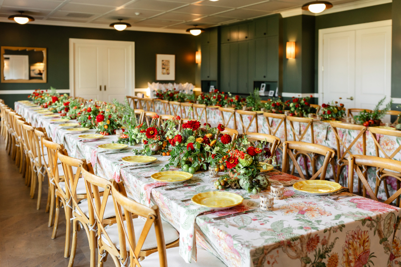 Heirloom tomato-inspired summer camp wedding welcome party tables set up.