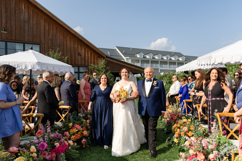 Bride is escorted down the aisle by her parents.