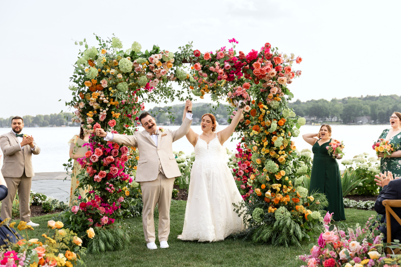 Bride and groom walk down the aisle after exchanging vows under floral filled chuppah at The Lake House on Canandaigua.