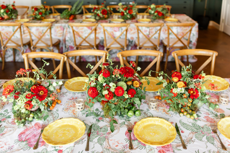 Heirloom tomato-inspired summer camp wedding welcome party floral arrangement.