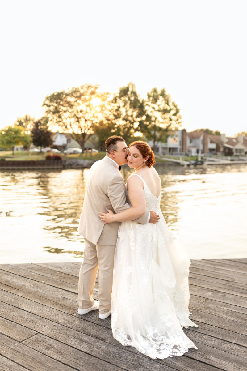 Bride and groom take pictures of dock at their summer camp wedding at The Lake House on Canandaigua.
