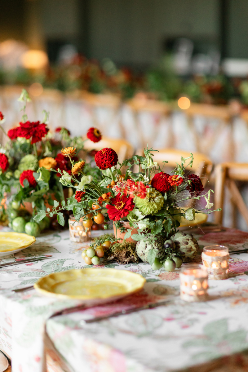 Heirloom tomato-inspired summer camp wedding welcome party floral arrangement.