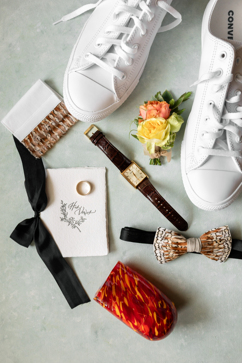Flatlay of groom's details for summer camp wedding.