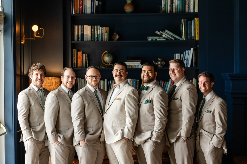 Groom poses with groomsmen before summer camp wedding.