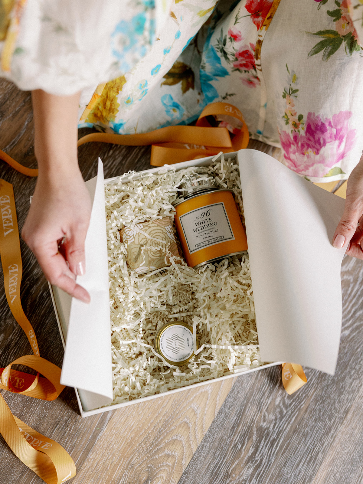 Wedding planner places gifts into box for new clients.