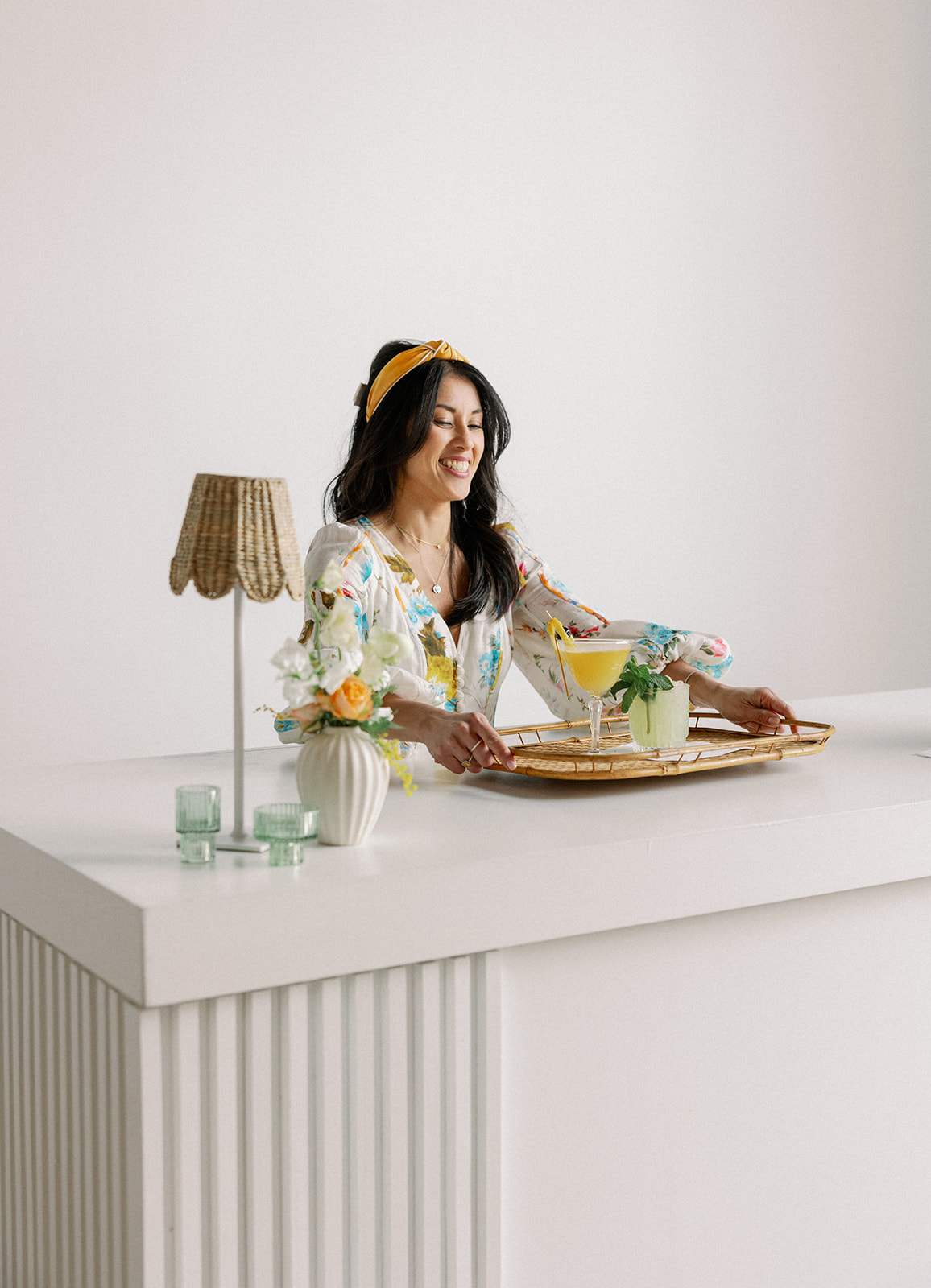 Wedding planner picks up tray of custom beverages she made for her branding shoot.