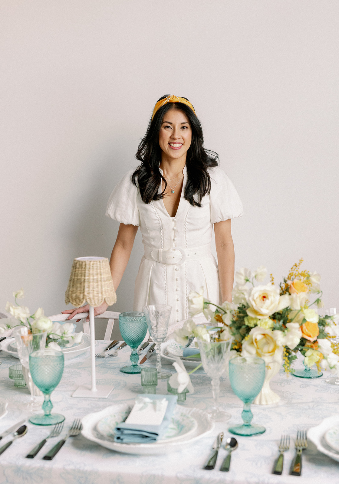 Planner stands behind decorated tablescape for a styled shoot wedding rebrand.