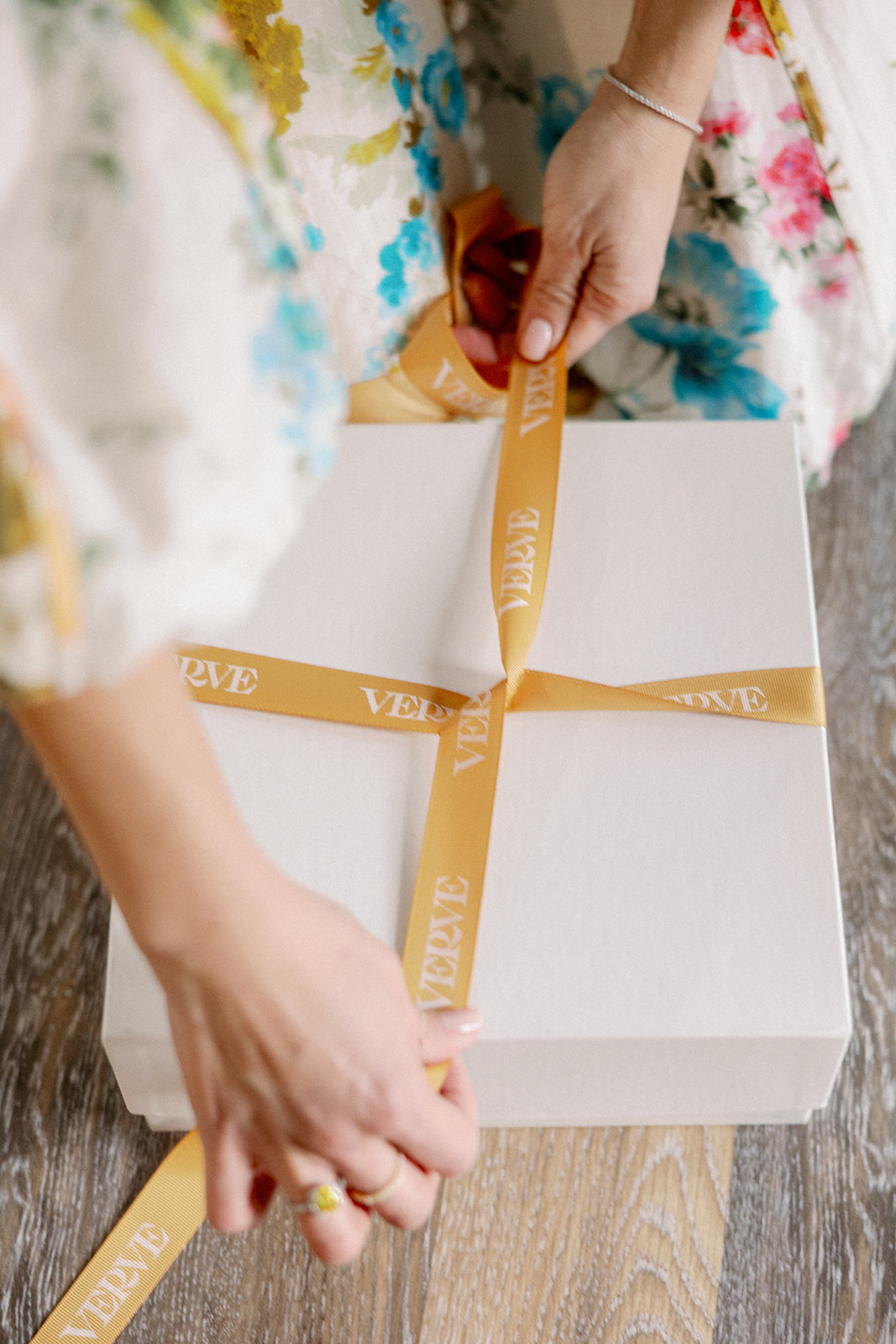 Wedding planner wraps white gift box with custom Verve Event Co. branded ribbon for her styled shoot wedding brand photos.