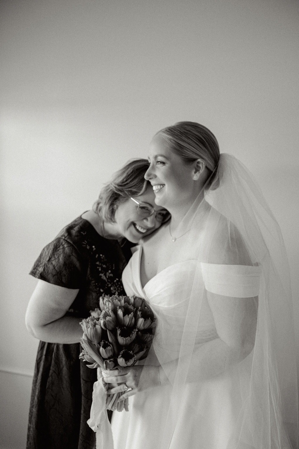 Black and white photo of mother and daughter hugging on daughter's wedding day.