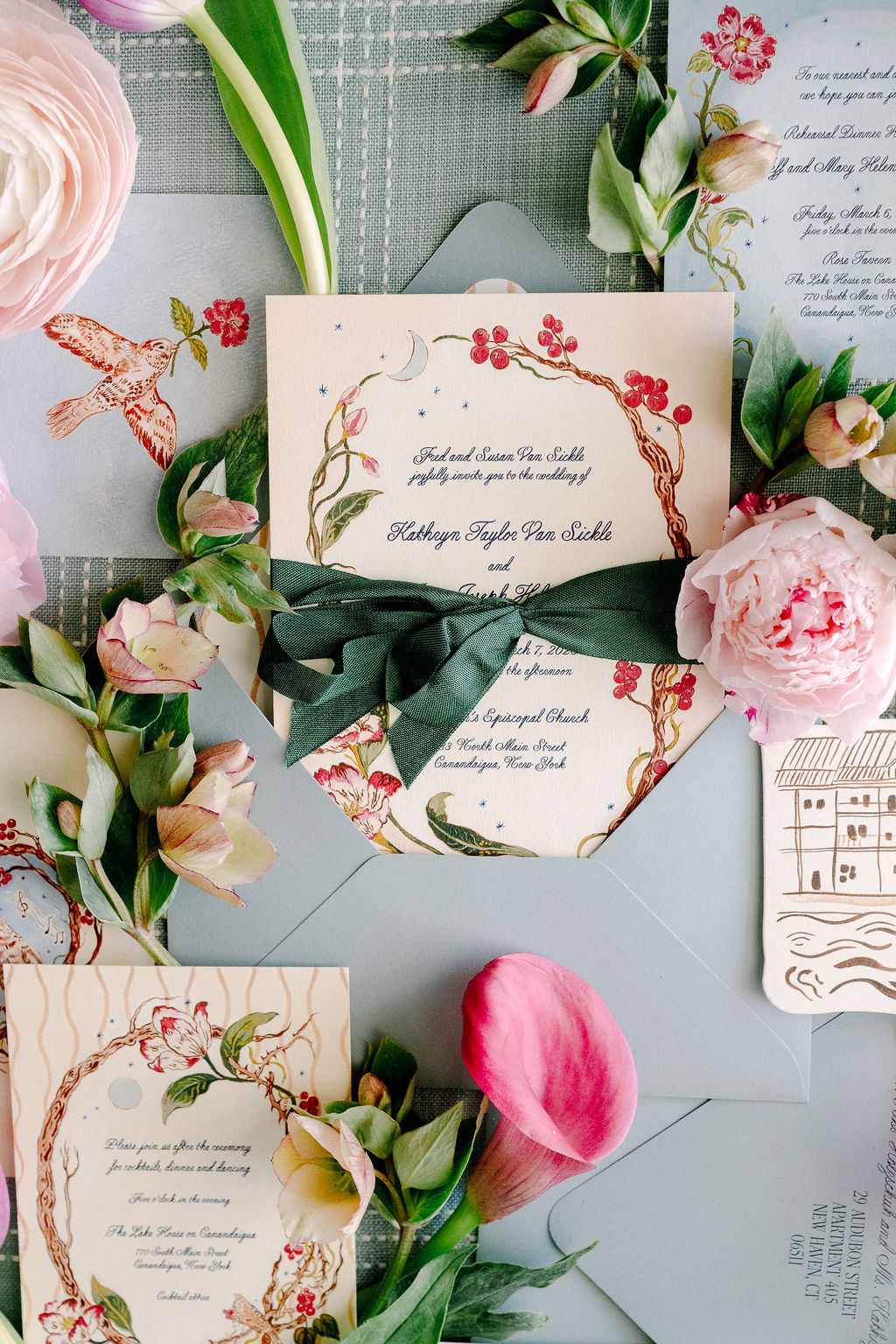 Flat lay of spring wedding details including custom stationery and tulips.