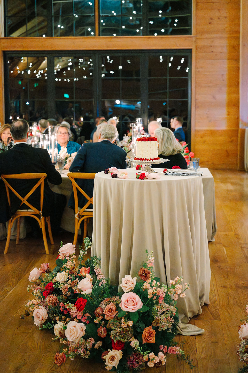 Wedding cake sits on cocktail table.