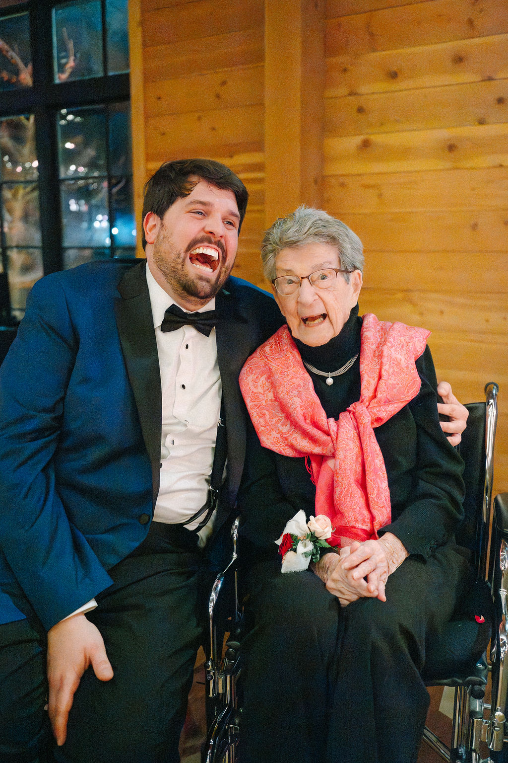 Groom hugs his grandmother at wedding reception.