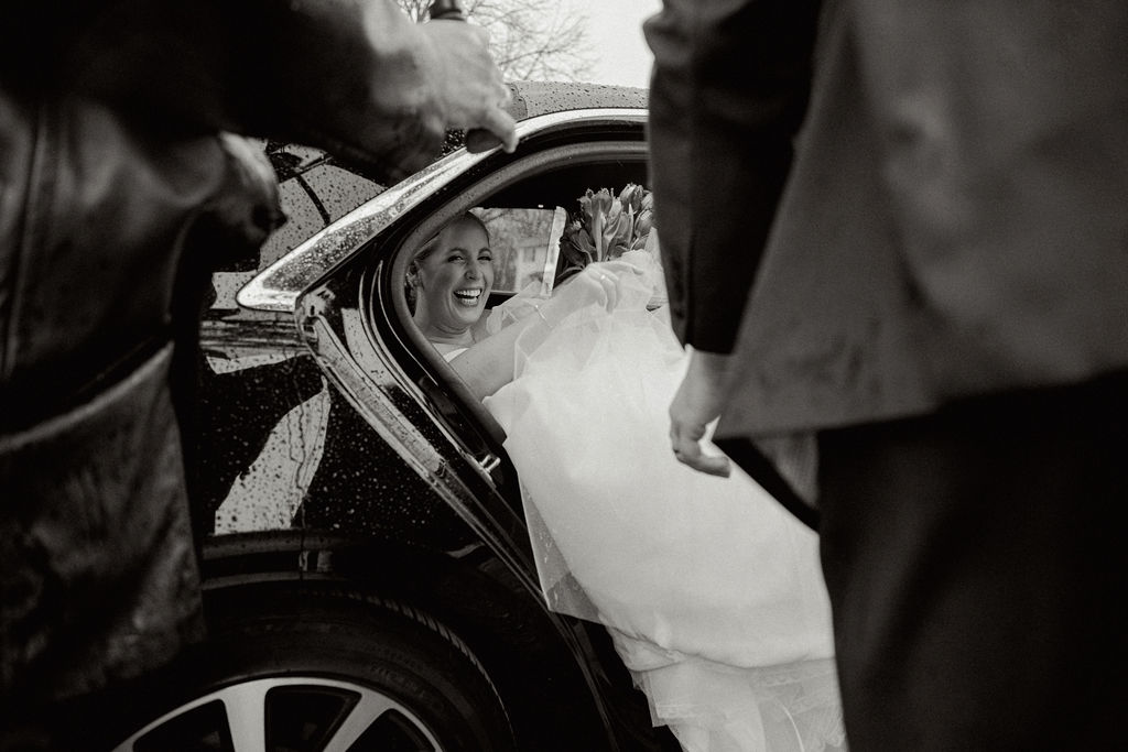 Bride gets into getaway car after wedding ceremony.