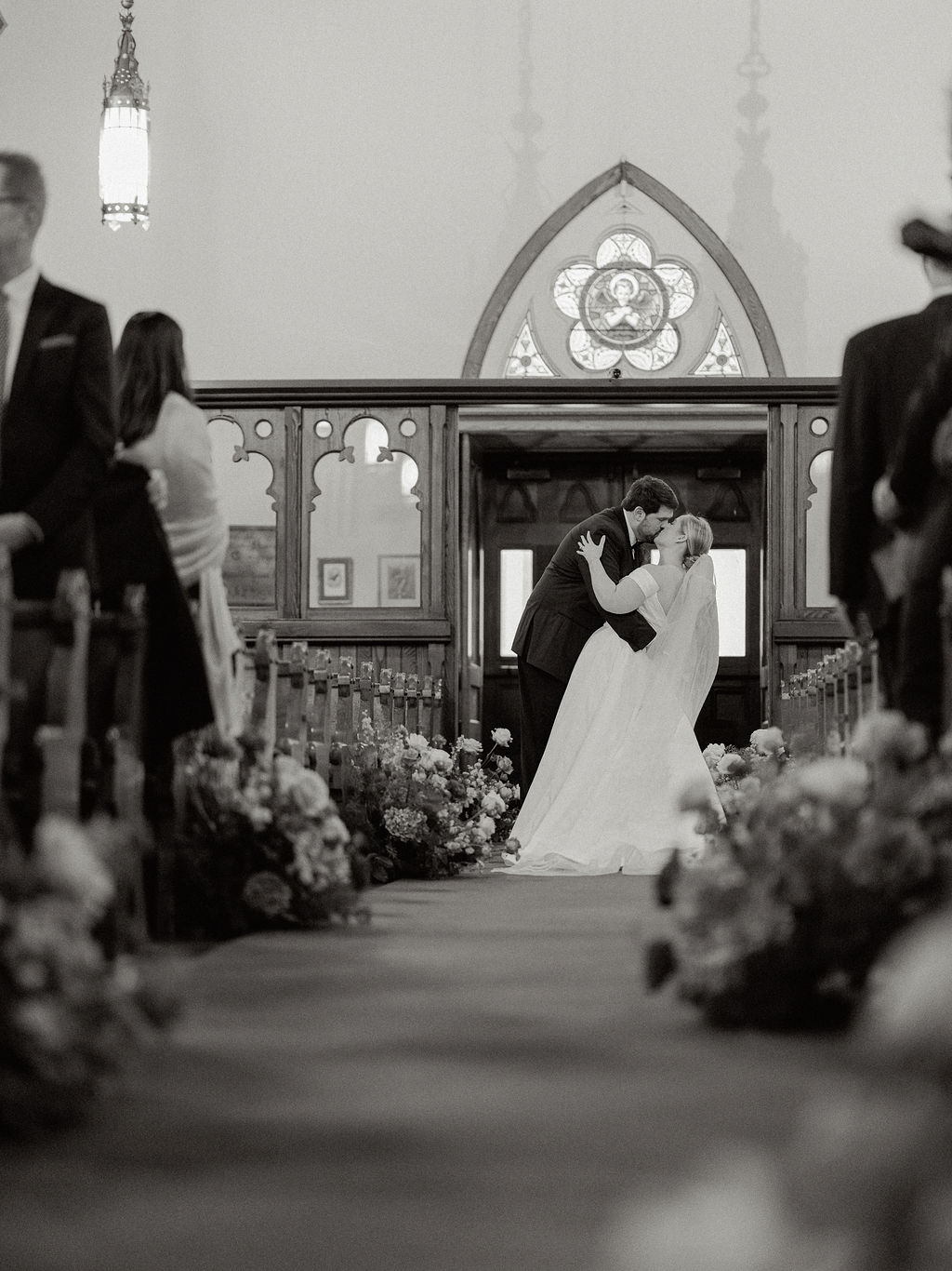 Groom dips bride for a kiss before they exit the church of their wedding ceremony.